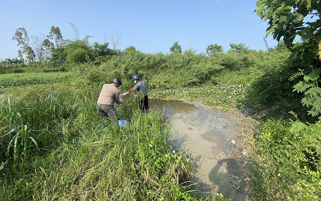 Cơ quan chức năng lấy mẫu nước tại một con kênh gần Cụm công nghiệp làng nghề Tịnh Ấn Tây
