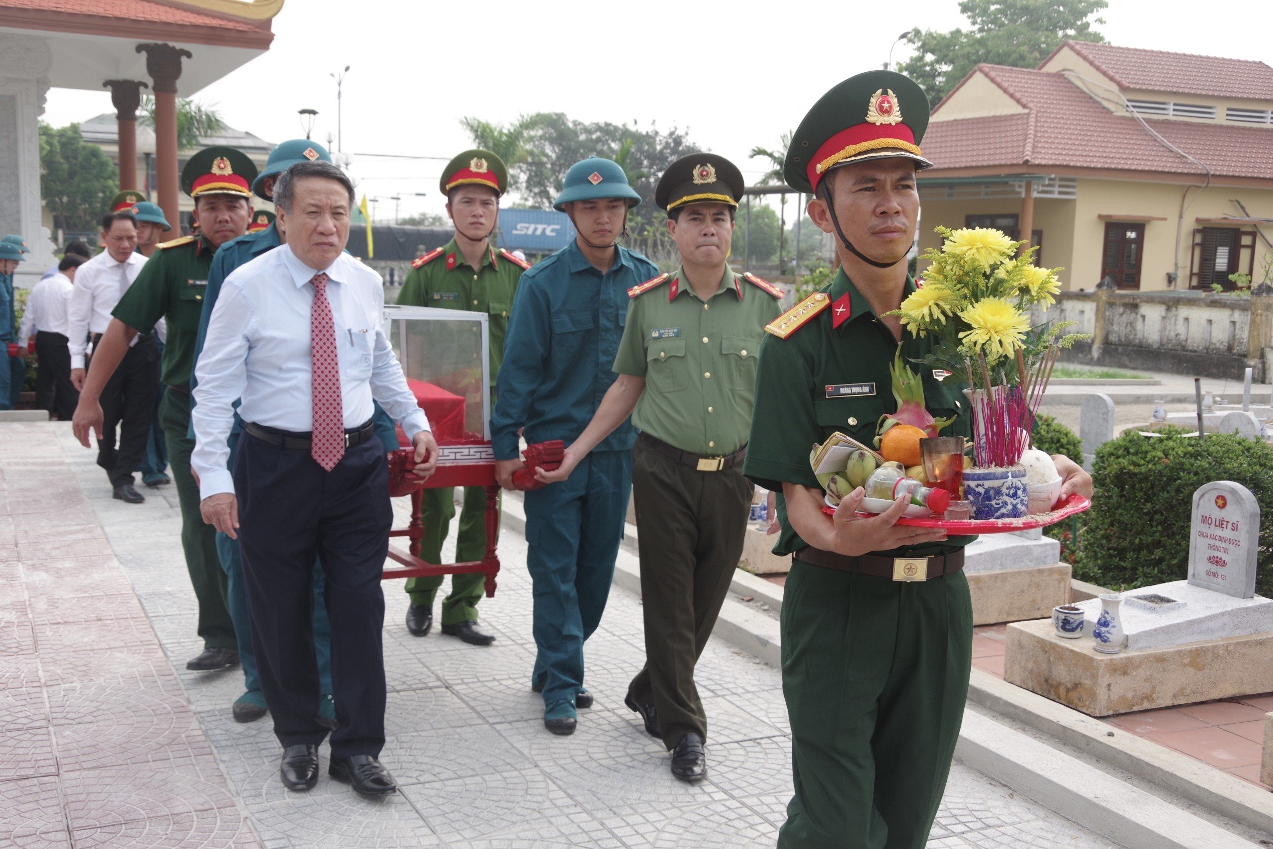 Ông Hà Sỹ Đồng (trái, Phó chủ tịch thường trực UBND tỉnh Quảng Trị) và đại tá Nguyễn Đức Hải (Giám đốc Công an tỉnh Quảng Trị) đưa liệt sĩ về nơi an nghỉ