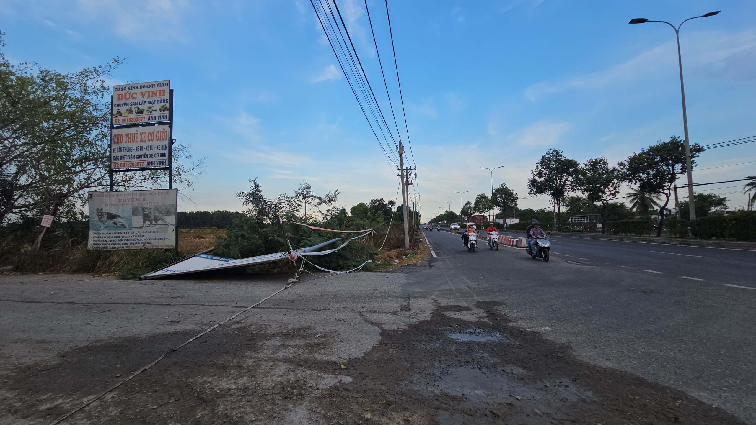 Biển quảng cáo có trụ bằng sắt trên quốc lộ 22 bị gió quật ngã