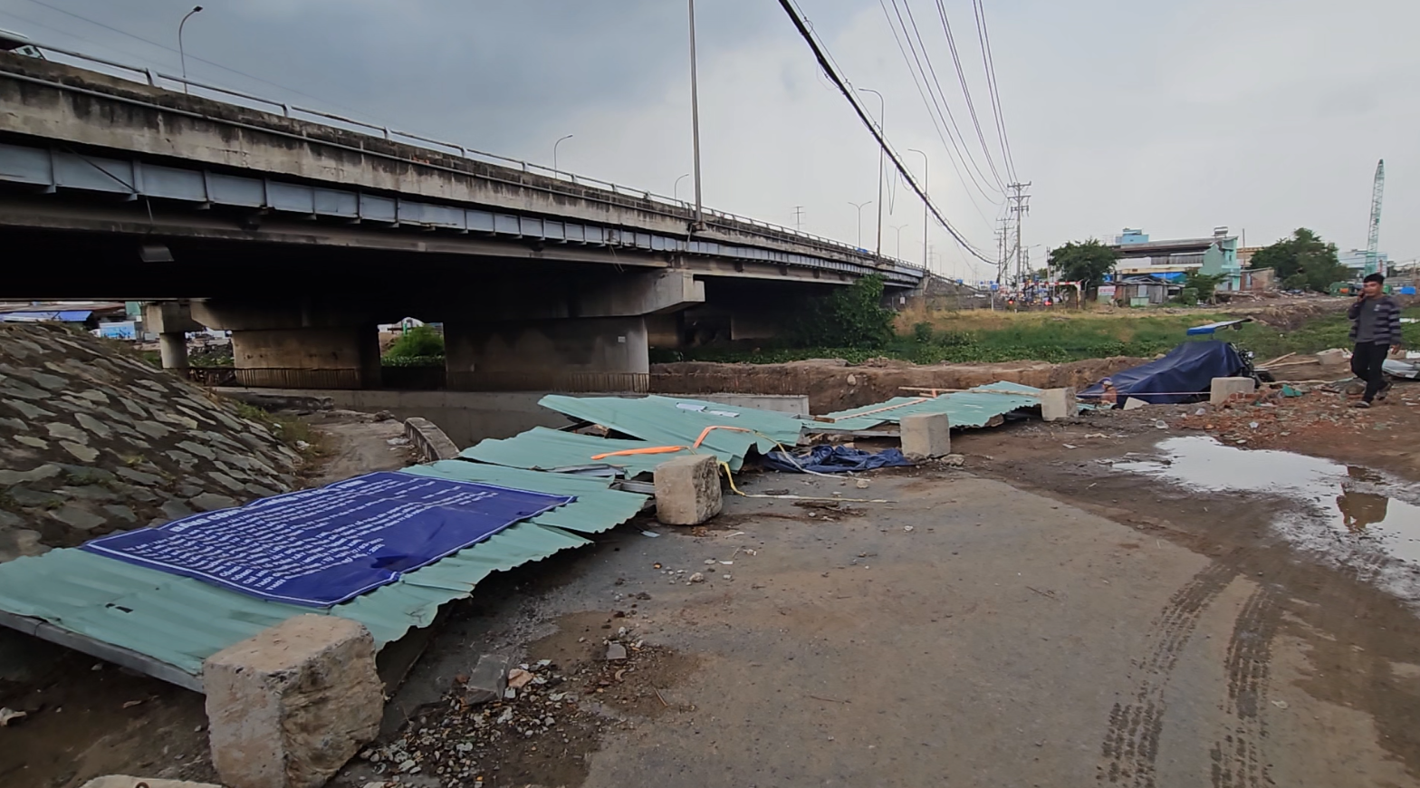 Cơn mưa kèm theo gió giật mạnh cuốn bay nóc 5 căn nhà cho thuê- Ảnh 2. Hàng rào tôn công trình thi công bờ kè tại chân cầu Bình Thuận bị gió quật ngã