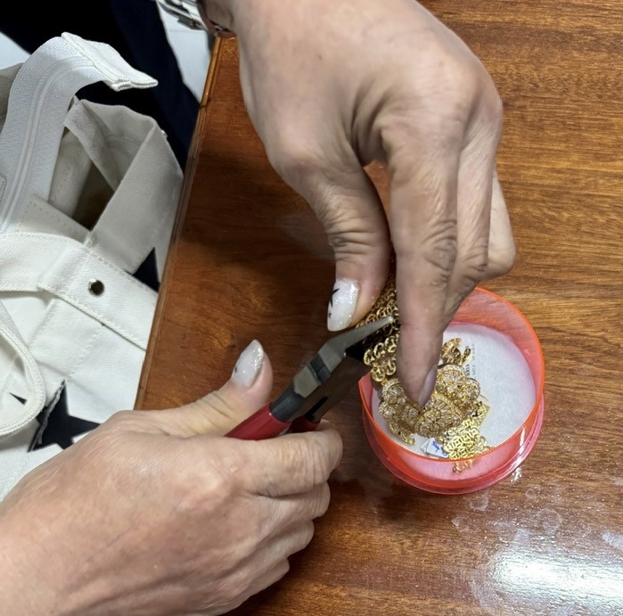 Cắt kim loại để cắt logo Chanel đính, đúc trên hàng hóa vi phạm của doanh nghiệp kinh doanh vàng