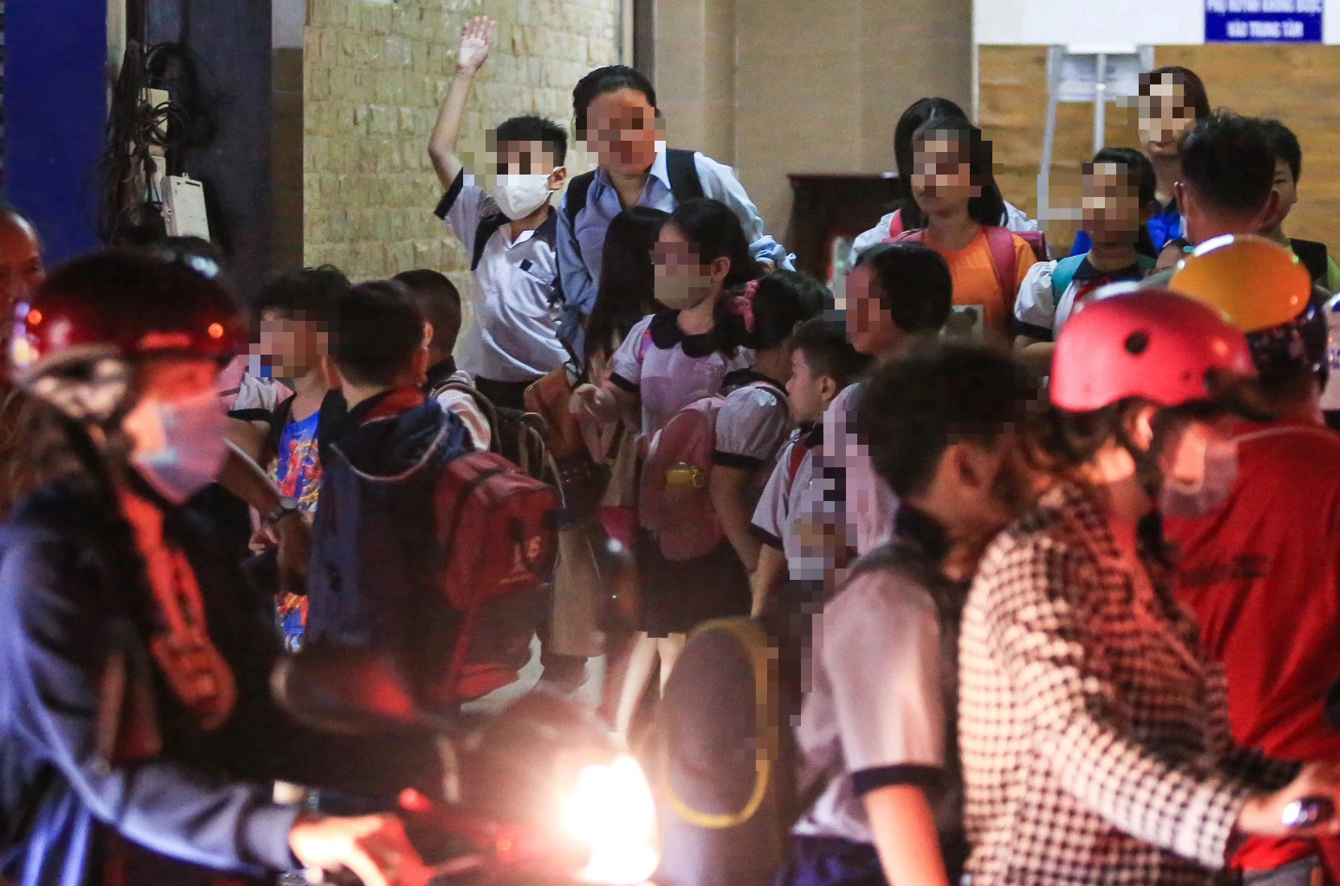 Cha mẹ đến đón trẻ tiểu học từ một trung tâm học thêm buổi tối