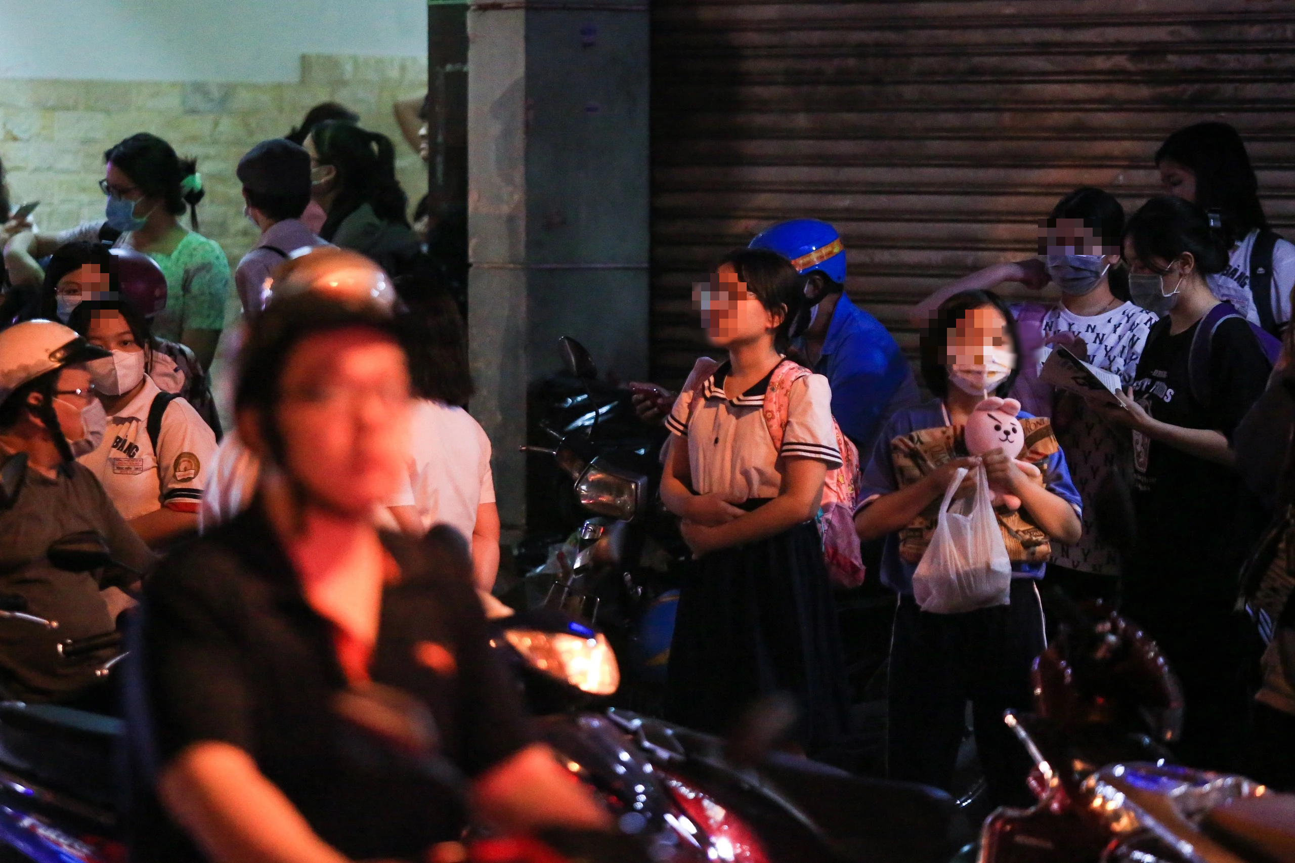 Vì sao cấm nhưng học sinh tiểu học vẫn học thêm?- Ảnh 2. Học sinh tiểu học chờ người thân sau buổi học thêm, hình ảnh quen thuộc trước các trung tâm ngoại ngữ, trung tâm bồi dưỡng kiến thức ở những thành phố lớn