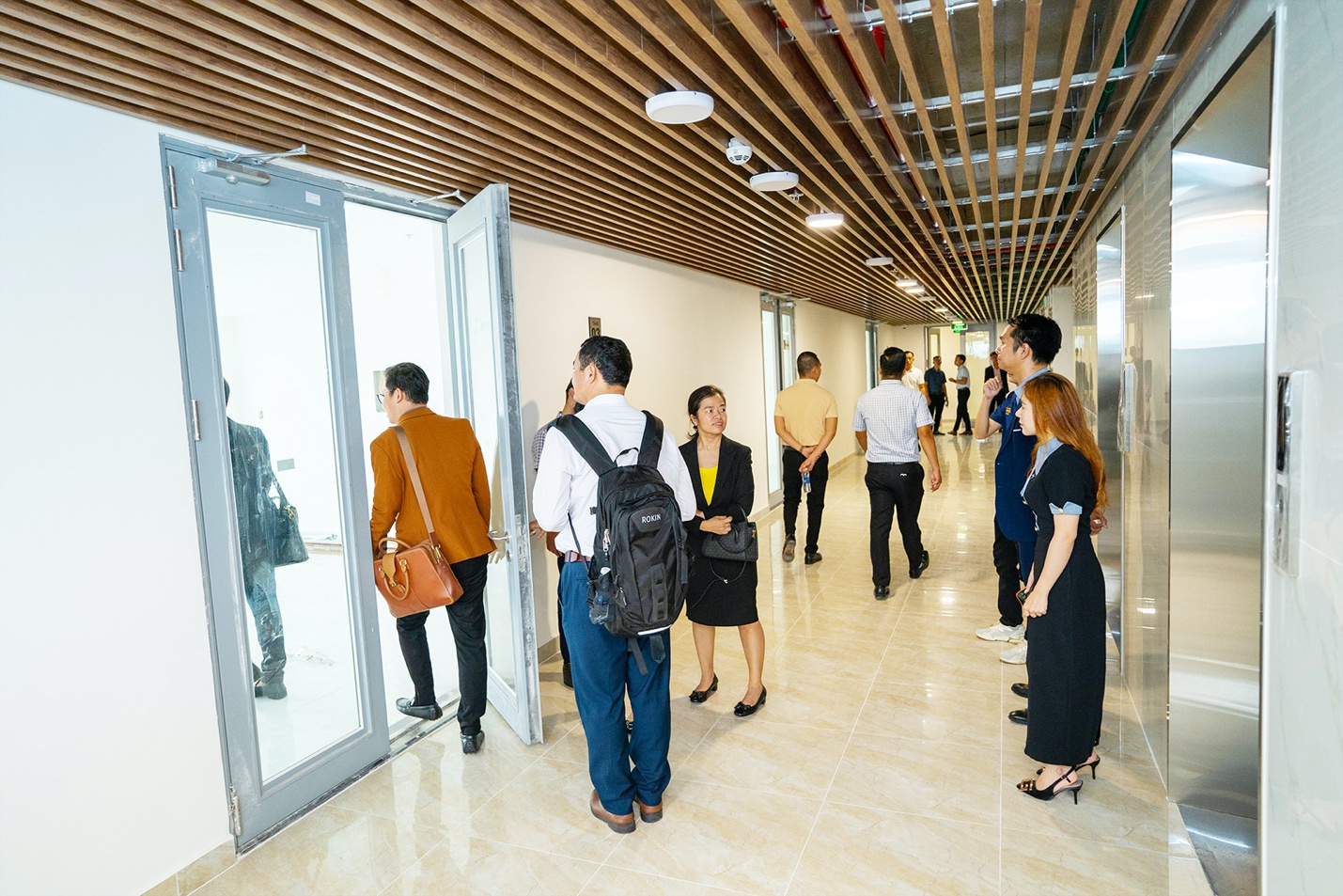 A group of people standing in a hallway  Description automatically generated