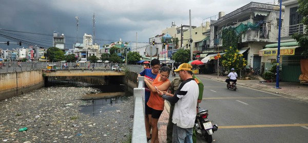 Người dân tập trung quanh bờ kênh xem lực lượng chức năng tìm bắt cá sấu