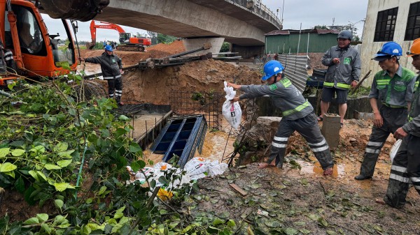 Dùng bao cát bịt miệng cống, ngăn nước lũ tràn vào trung tâm TP.Quảng Ngãi cũ