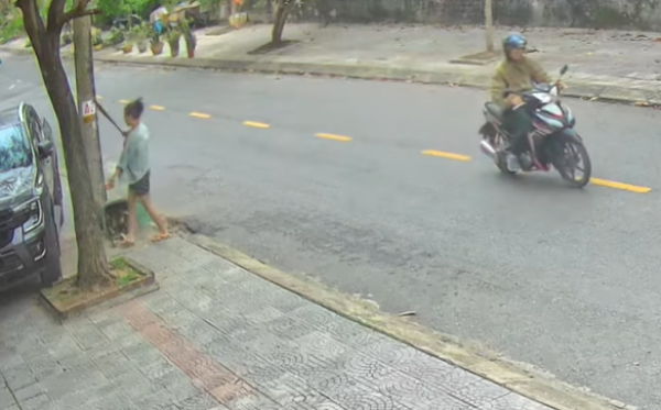 Người phụ nữ dùng gậy, rựa đập phá ô tô đậu ven đường