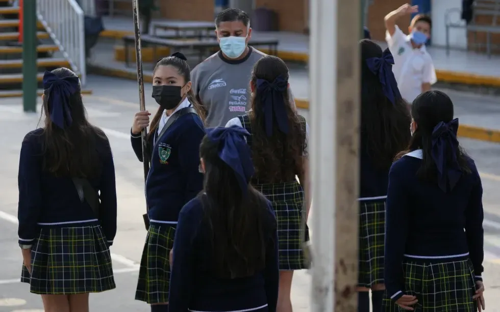 Học sinh và giáo viên đeo khẩu trang bắt buộc trong lễ chào cờ tại một trường công lập ở Guadalajara, Mexico, ngày 5/2/2026 (Ảnh: AP)